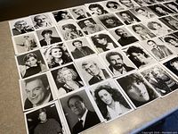 Top flat layout of 50 black-and-white celebrity headshots on a table, showing various actors from 1970s to 1990s, arranged in rows.