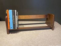 Front view of the wooden tabletop bookshelf with some books to demonstrate use