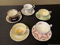 Front view of five vintage teacups and saucers in various floral patterns and colors
