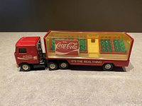 Side view of the complete red Buddy L Coca Cola truck and attached trailer with clear lid showing Coca Cola logos and slogan.