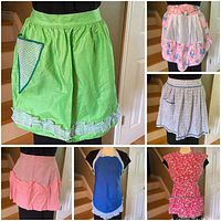 Six vintage handmade kitchen aprons displayed on a mannequin showing different colors and styles including full smock and half aprons