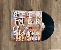 Front cover of Deer Tick Divine Providence vinyl showing album artwork with black vinyl partially out of sleeve.