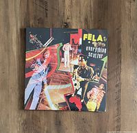 Front cover of sealed Fela Kuti Everything Scatter LP with colorful collage design and images of the artist.