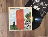 Front cover of Wonderwall Music LP by George Harrison showing iconic artwork and vinyl record partially out of sleeve.