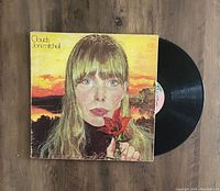 Photo of the Joni Mitchell Clouds vinyl LP record with original album cover jacket and the vinyl partially taken out showing the record label.