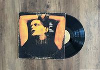 Photo of Lou Reed 'Rock And Roll Animal' LP vinyl record partially out of its album jacket showing front cover artwork and vinyl surface.