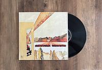 Front view of Stevie Wonder Innervisions vinyl record partially out of its gatefold sleeve, showing the album artwork and black vinyl disc.