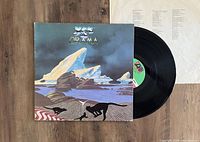 Vinyl record partially out of cover showing original album art and black vinyl disc with Yes label.