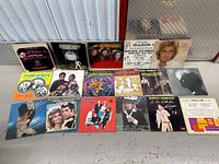 Photo of 17 vinyl album records spread on the floor showing front album covers.
