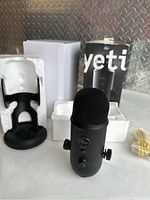 Image showing Blue Yeti microphone standing upright with stand, white styrofoam inserts, and original box in background.