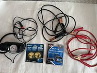 Photo showing tire inflator, jumper cables, blind spot mirrors, and deer warning device on white background