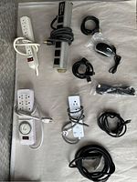 Top view of all items laid on white sheet showing power centres, cords, mouse and cables.
