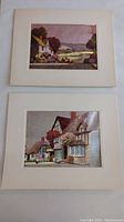 Two foil art landscape prints on cardboard mount showing rural cottage scenes.