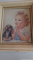Framed vintage art print showing a blond child and a dachshund dog, detailed close-up of artwork and frame.