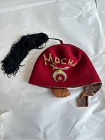 Photo showing full front and leather wear of the red Masonic Shriner fez hat with black tassel