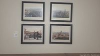 Four black framed photographs on a wall showing scenic views of Spain including architecture and cityscapes