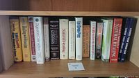 Shelf with 16 assorted books in various topics including health, fitness, and natural healing