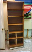 Front view of the brown wooden bookcase showing adjustable shelves and lower compartments.
