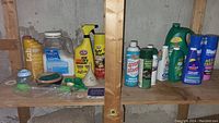 Wide shelf view of all cleaning products and tools including multiple spray bottles and detergent containers.
