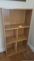 Front view of the MDF bookcase showing three shelf tiers with dividers on lower shelves.