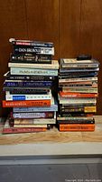 Photo showing a stack of 31 paperback books with titles in various genres including fiction, biography, and music.