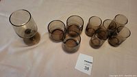 Top view of all glasses on light surface: 5 juice glasses, 3 larger glasses, 1 wine glass