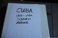 Closed white binder stamp album with a blank handwritten title sheet stating 'CUBA 1855-1990 STAMP ALBUM'.