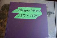 Front cover of large purple binder with handwritten green tape label 'Hungary Stamps 1871-1975'.