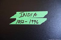 Green tape label on black album cover with hand-written text 'INDIA 1852 - 1996'.