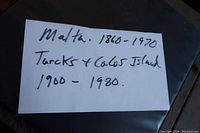 White card with handwritten note detailing the contents of the album: Malta stamps from 1860 to 1970, Turks and Caicos Islands from 1900 to 1980.