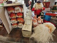 Full lot view showing all pieces including boxed hanging Santa heads, angel candle holders, small Santa figurines, large golfing Santa, and large Santa head.