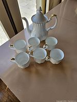 Seven-piece Royal Albert coffee set with coffee pot and six cups shown together on table.