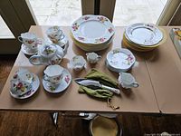 Overview of all flatware and serving pieces arranged on tabletop