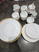 Overview of cups, teapot, sugar bowl, creamer, and plates on countertop