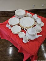 Overhead view of entire dinnerware collection arranged on red tablecloth.