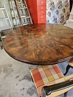 Round burled maple veneer tabletop with swirling grain pattern
