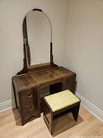 Full view of dressing table with bench and mirror attached, showing polished wood grain and drawer handles