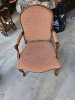 Front view of the French Louis XV style armchair showing fabric upholstery and wooden frame with carved details.