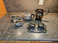 7 piece silver plated tea and serving set displayed on counter