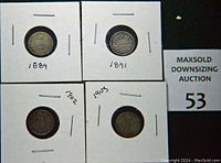 Front sides of four silver dimes from 1889, 1891, 1902 and 1903 in white card holders.