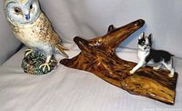 Beswick glazed barn owl figurine next to wood and ceramic dog figurine on natural wood base