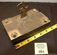 Lock body with key inserted and measuring tape showing approximately 6 inches length