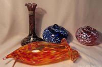 Full view of all four items showing the wall hanging and three vases in different colors and shapes