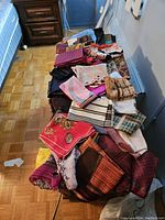 Full view showing large collection of various men's and ladies scarves laid out on a surface, assorted colors and patterns visible.