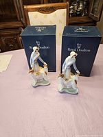 Pair of Royal Doulton Daisy Blue figurines on table with boxes behind them