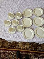 Full set showing 6 dessert plates, 6 cups and 6 saucers arranged on a table with lace tablecloth, displaying the overall quantity and styling of the porcelain set.