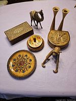 Full view of all wooden items arranged showing candle holders, camel, monkey, trinket boxes, and decorative plate