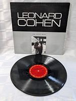 Photo of the LP vinyl itself laying flat, showing the red label and visible grooves, indicating the record's format and condition.