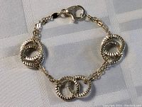 Full view of the sterling silver bracelet or anklet showing chain, textured circular links, and lobster clasp.