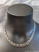 Front view of sterling silver braided necklace displayed on black mannequin bust showing full 17.5 inch length and braided design